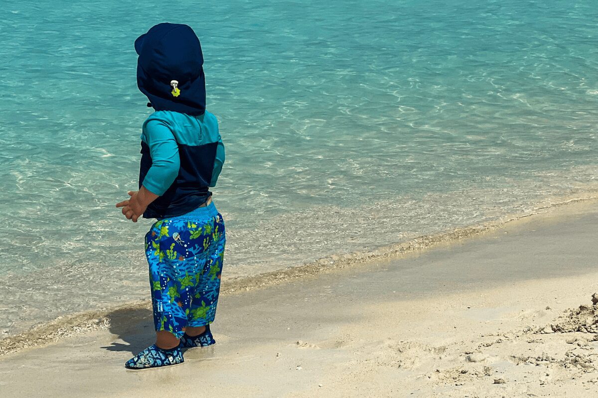 Toddler with sun hat on the beach