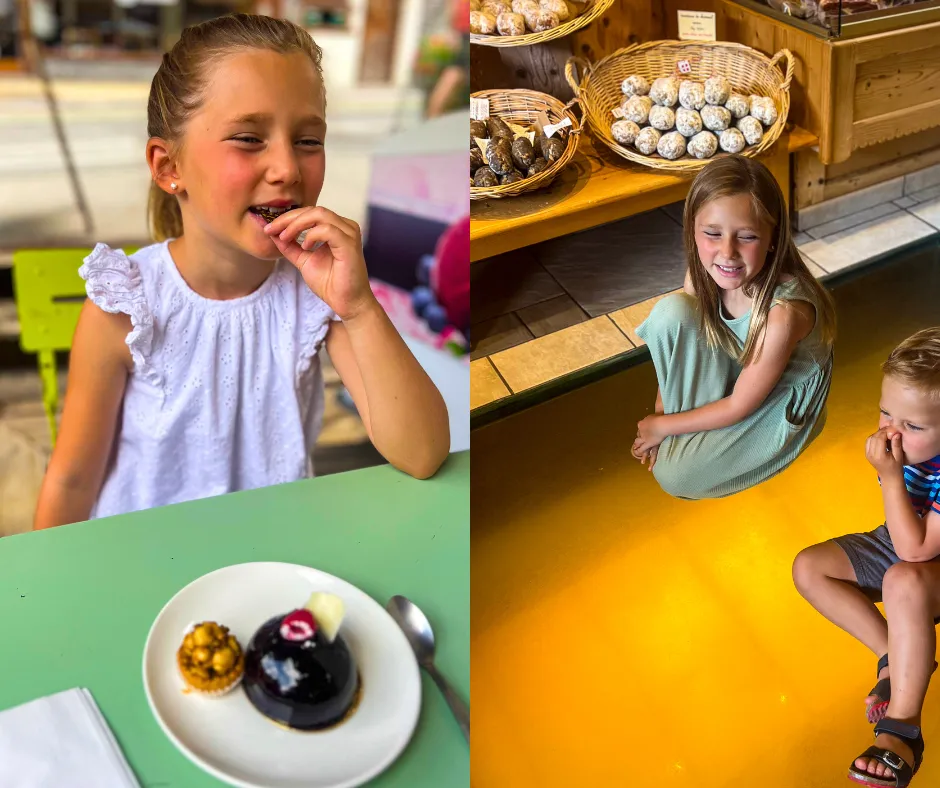 Kids enjoying desserts in French Alps: girl in white tastes chocolate pastry at a green table; bakery scene with pastries.